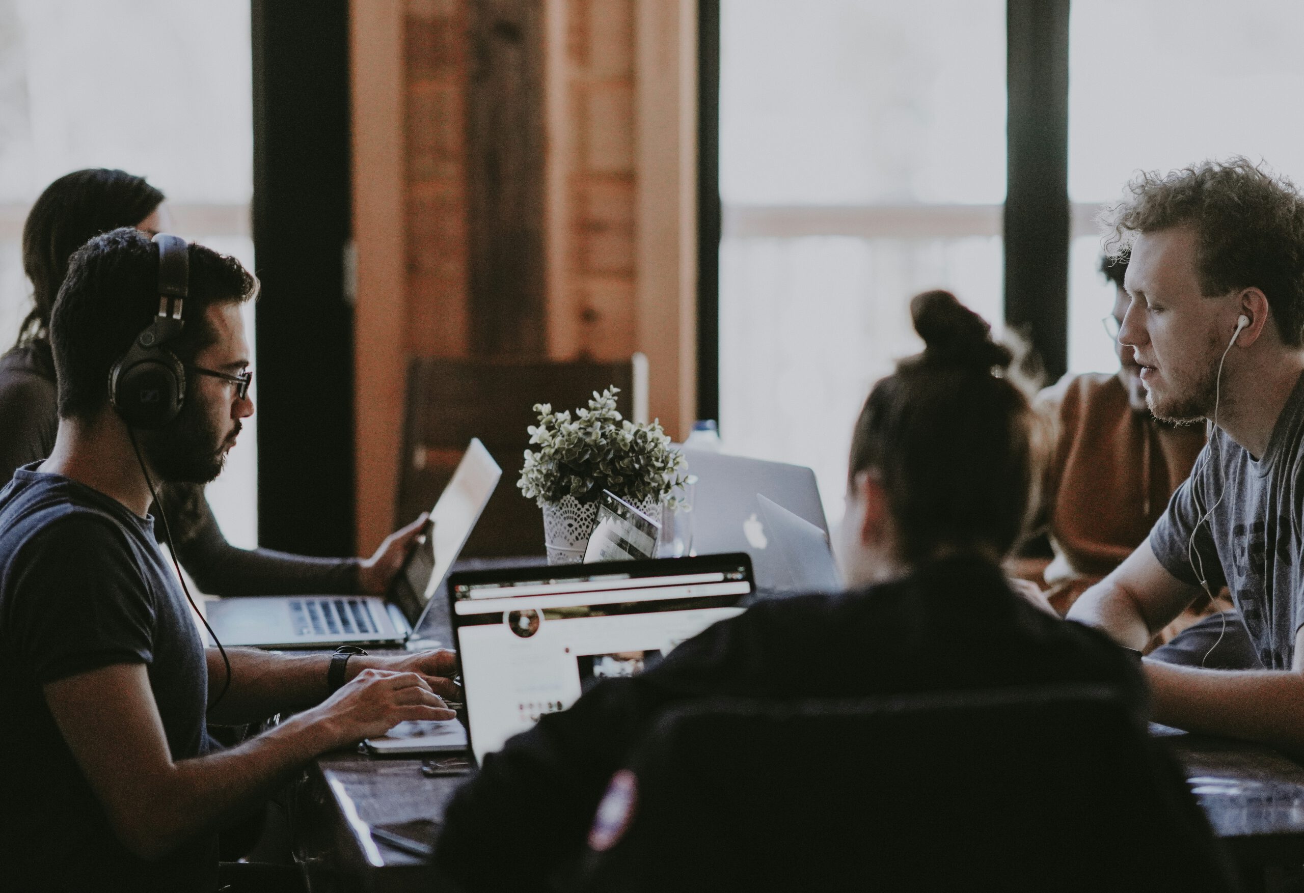 Team samenwerkend in een modern kantoor, begeleid door Roveijco in Agile en Scrum coaching, met een focus op productiviteit en samenwerking.